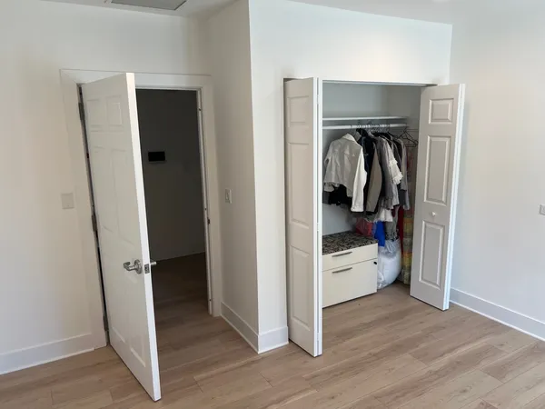 a view of walk in closet with clothes and shoes