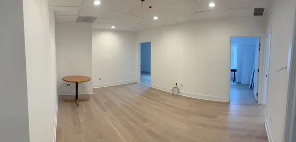 an empty room with wooden floor and glass door