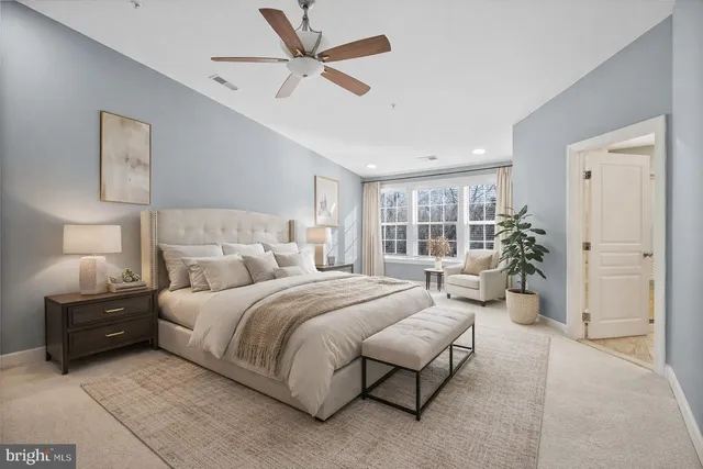 a bedroom with a large bed and a chandelier