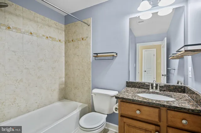 a bathroom with a granite countertop sink toilet and shower