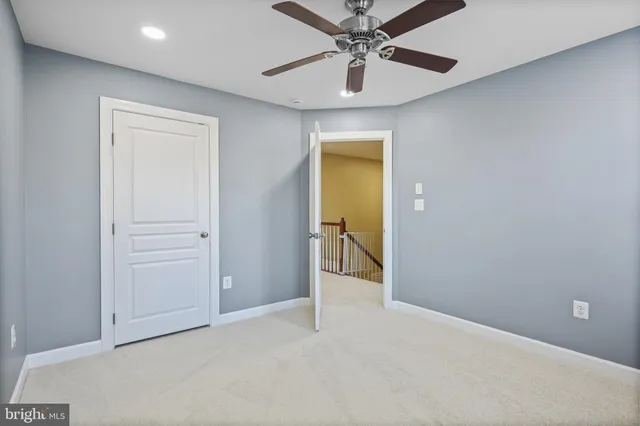 en empty room with closet and a chandelier fan