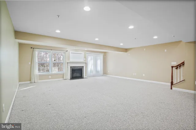 a view of an empty room with a fireplace and a window