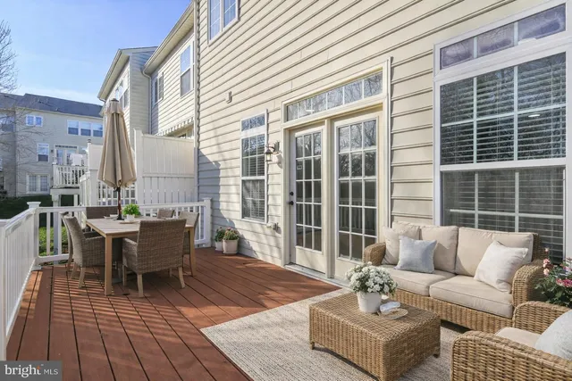 a view of a patio with couches table and chairs and potted plants