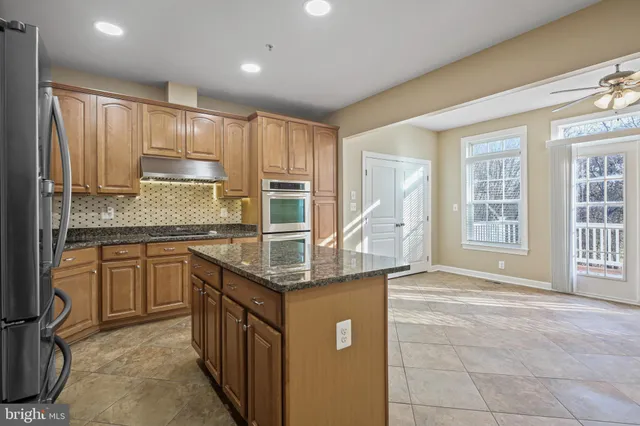 a kitchen with stainless steel appliances granite countertop a sink stove and cabinets