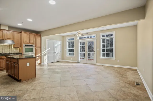 a view of kitchen with kitchen island granite countertop wooden cabinets and stainless steel appliances