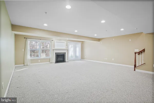 a view of an empty room with a fireplace and a window