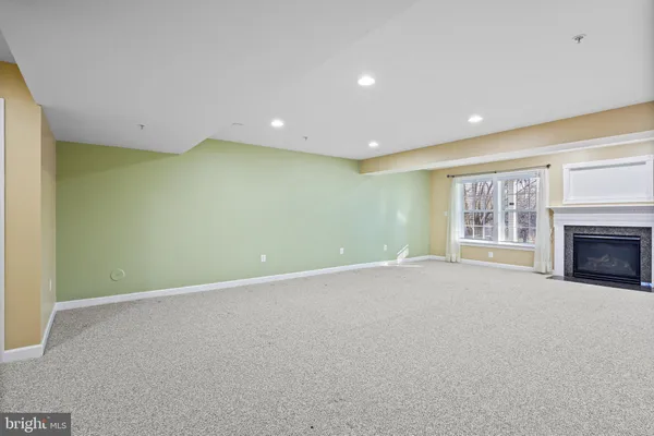 a view of an empty room with a fireplace and a window