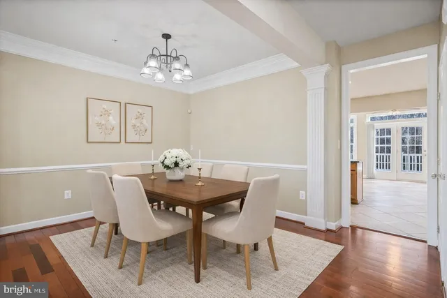 a view of a dining room with furniture wooden floor and a chandelier