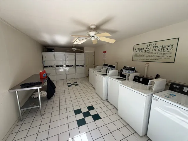 a room with furniture a flat screen tv and kitchen view