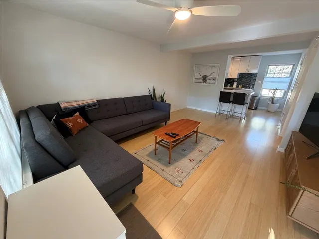 a living room with furniture and a wooden floor