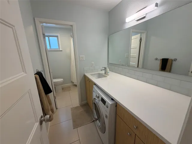 a bathroom with a sink a toilet and a mirror