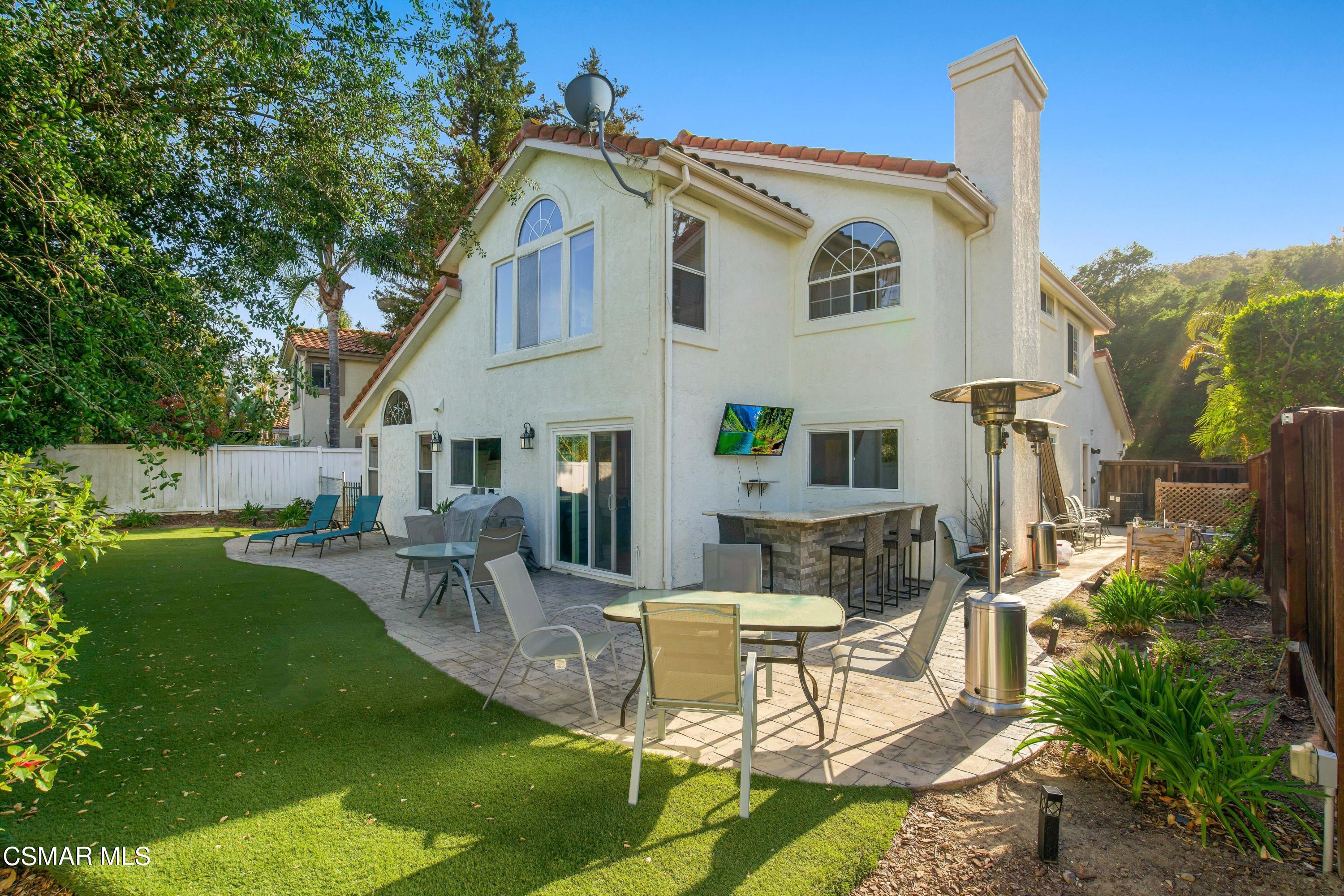 486 Fresh Meadows Road Simi Valley, CA 93065 - Photo 24 of 30 a view of a patio with table and chairs potted plants and a large tree