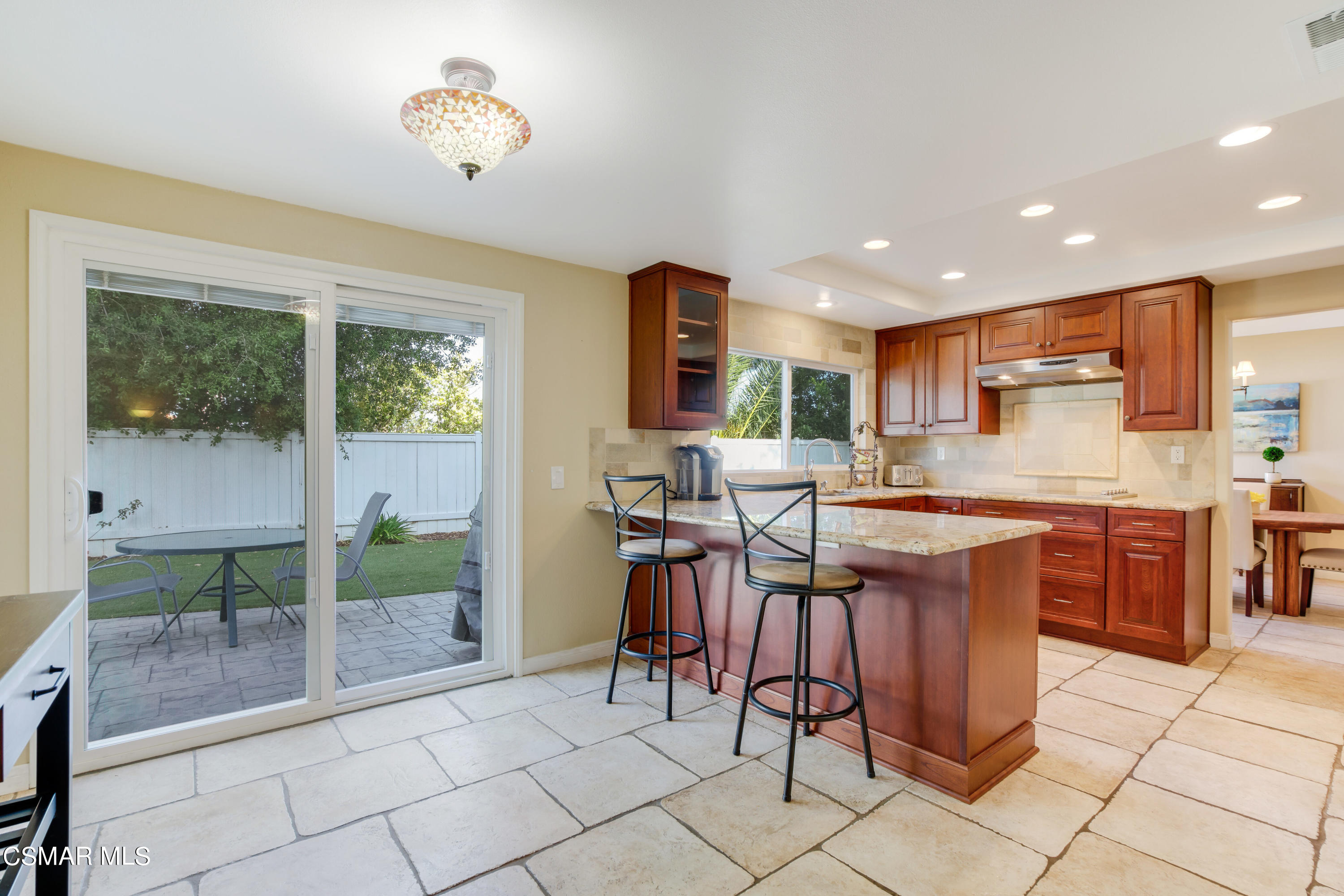 486 Fresh Meadows Road Simi Valley, CA 93065 - Photo 10 of 30 a kitchen with stainless steel appliances granite countertop a stove a sink a dining table and chairs