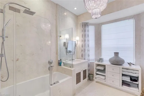 a bathroom with a tub sink shower and mirror