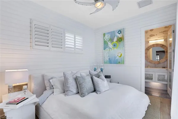 a bedroom with a bed and painting on the wall