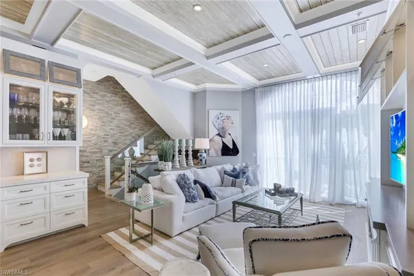 a living room with furniture and large windows