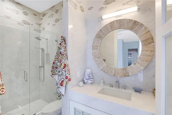 a bathroom with a sink mirror vanity and toilet