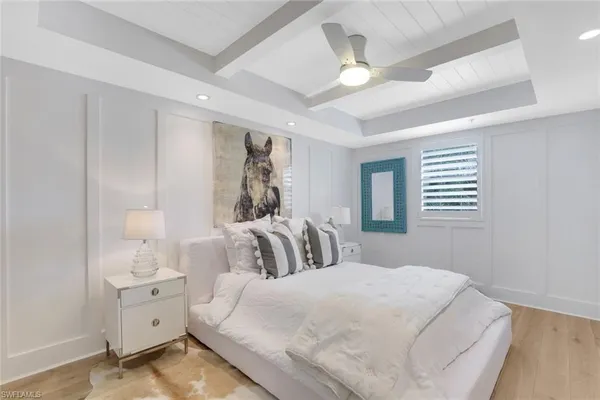 a bedroom with a white bed and a chandelier