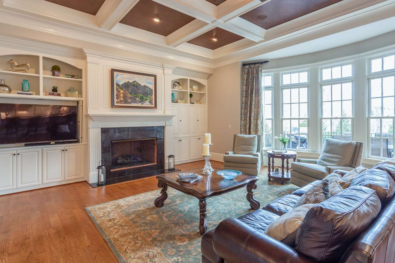 3032 Cone Manor Lane Raleigh, NC 27613 - Photo 5 of 30 Features include double bookcases that frame the beautiful gas fireplace, dual locations for wide screen television, coffered ceiling with painted faux leather interior, hardwood floors, distributed audio and gorgeous wall of windows overlooking the pool. Open Family Room