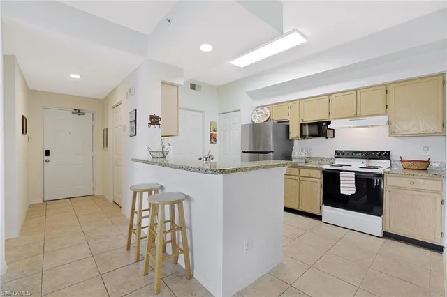 a kitchen with a sink a stove top oven and white stainless steel appliances