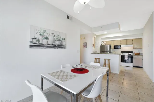 a living room with furniture kitchen view and a wooden floor