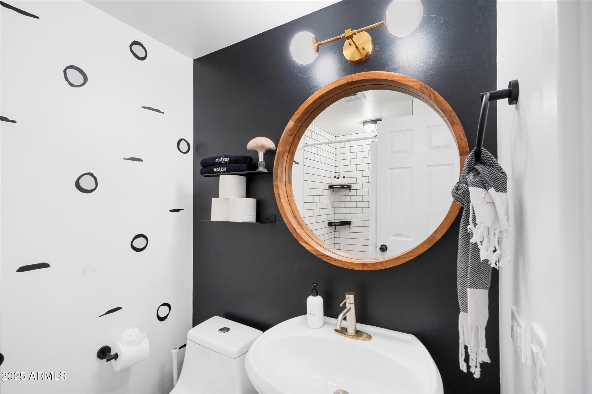 2307 North 51st Place Phoenix, AZ 85008 - Photo 29 of 41 a bathroom with a sink a mirror a toilet and shower