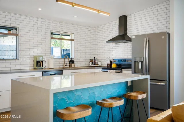 a kitchen with stainless steel appliances a sink a table and chairs in it