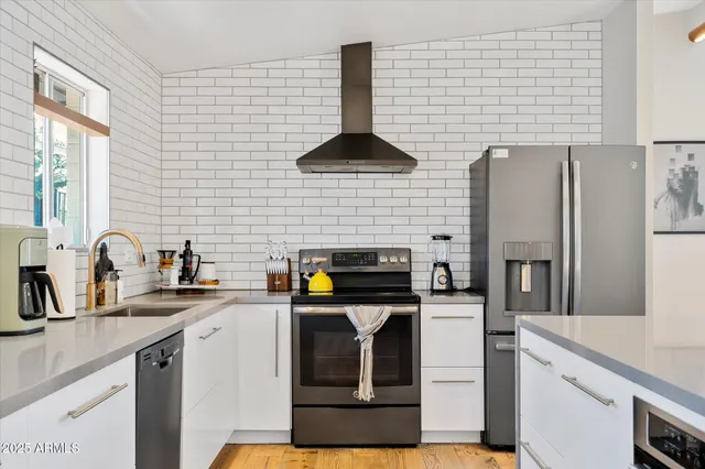 a kitchen with stainless steel appliances a sink a stove and a refrigerator