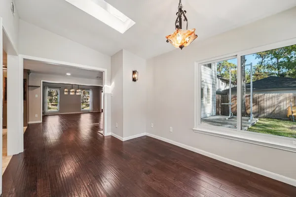 a view of a hallway with wooden floor and a chandelier