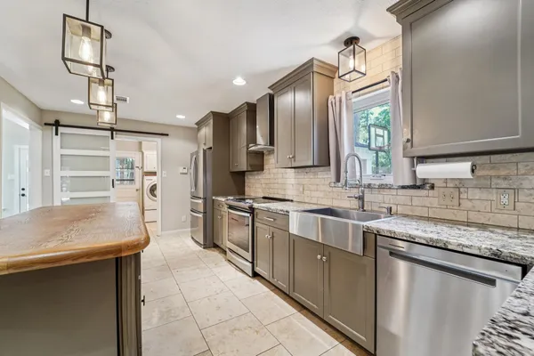 a kitchen with stainless steel appliances granite countertop a sink stove and refrigerator
