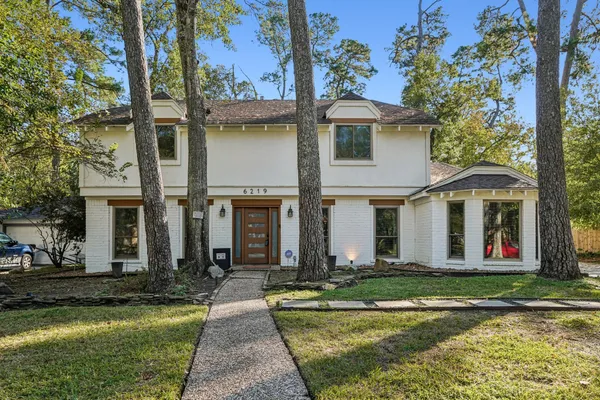 a front view of a house with swimming pool and a garden