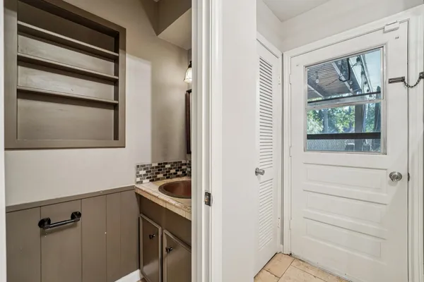 a bathroom with a window sink and mirror