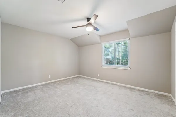 an empty room with a window and a fan