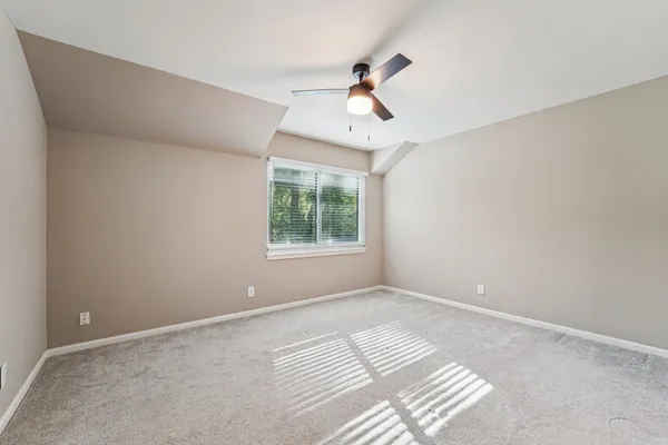 a view of a livingroom with a chandelier fan and windows