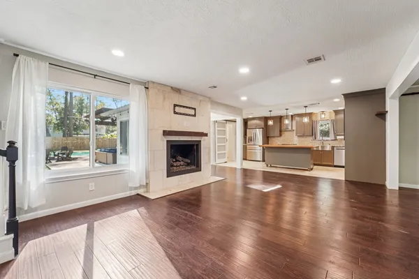 a view of empty room with wooden floor and fireplace