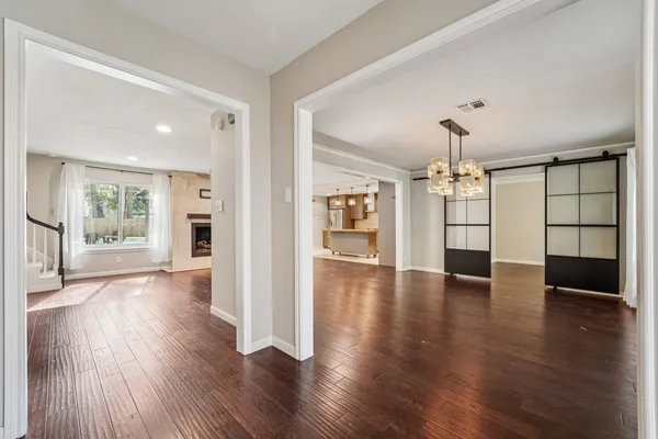 a view of a big room with wooden floor and a kitchen