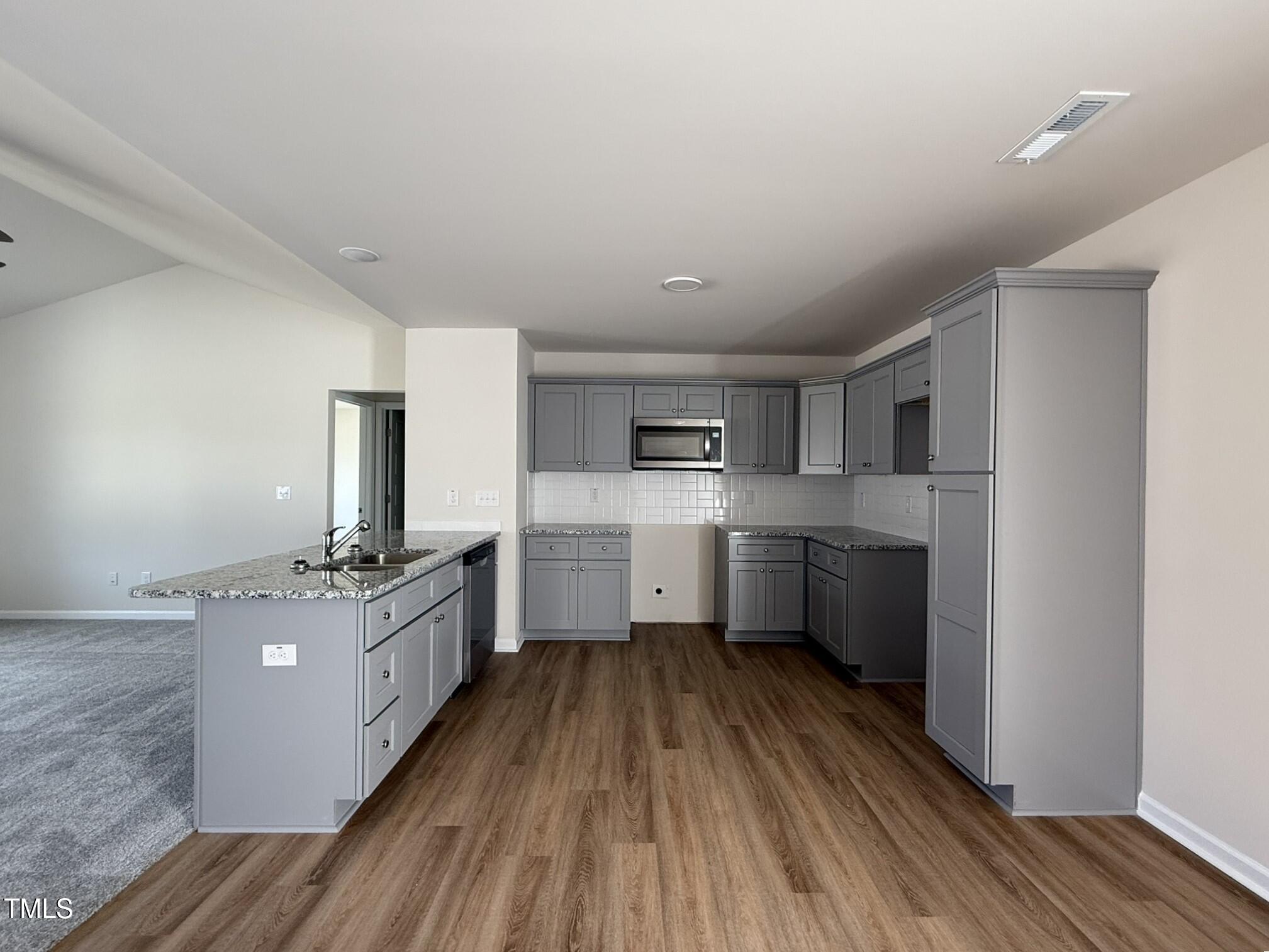 73 Phil Jack Road Dunn, NC 28334 - Photo 8 of 17 a kitchen with stainless steel appliances a sink wooden floor and cabinets