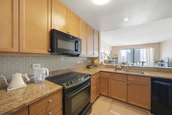 a kitchen with stainless steel appliances granite countertop a sink stove and microwave