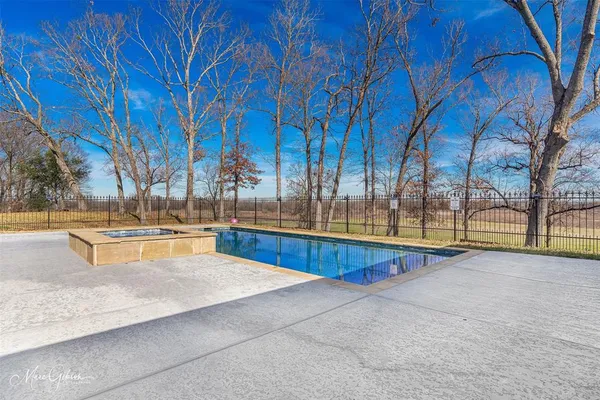 a view of swimming pool with trees and in backyard