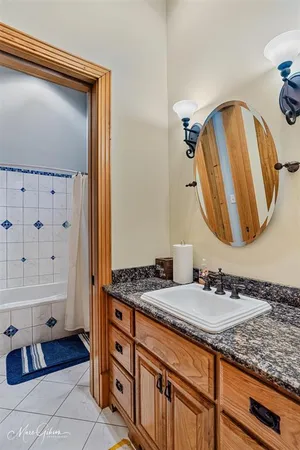 a bathroom with a granite countertop sink and a mirror