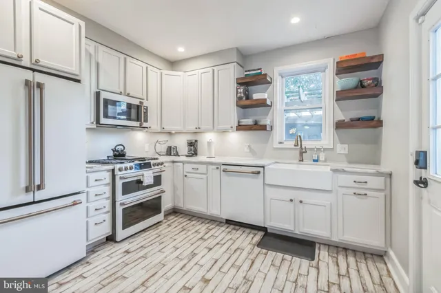 a kitchen with stainless steel appliances granite countertop a stove a sink and a refrigerator