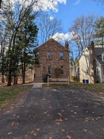 a view of a old house with a large tree