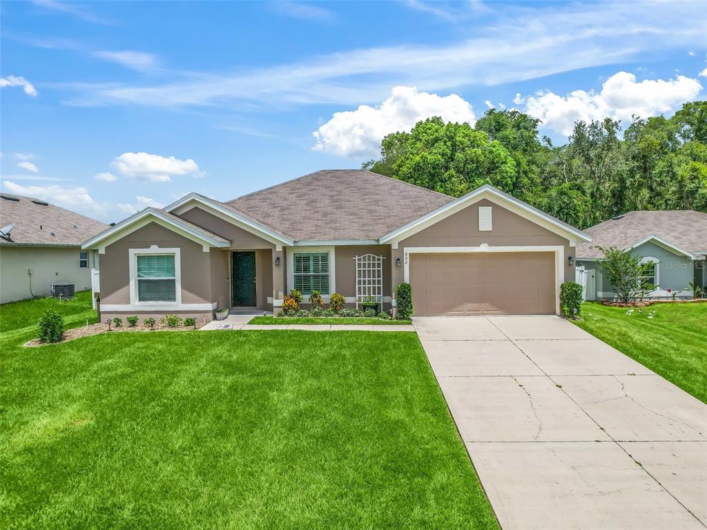 602 East Leah Court Fruitland Park, FL 34731 - Photo 1 of 33 a front view of a house with a garden