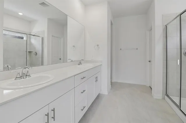 a bathroom with double sink and a mirror