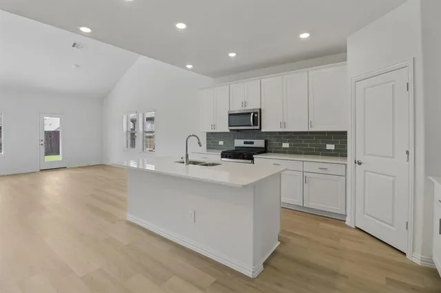 a kitchen with cabinets a sink and appliances