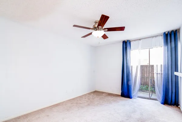 an empty room with closet and a ceiling fan