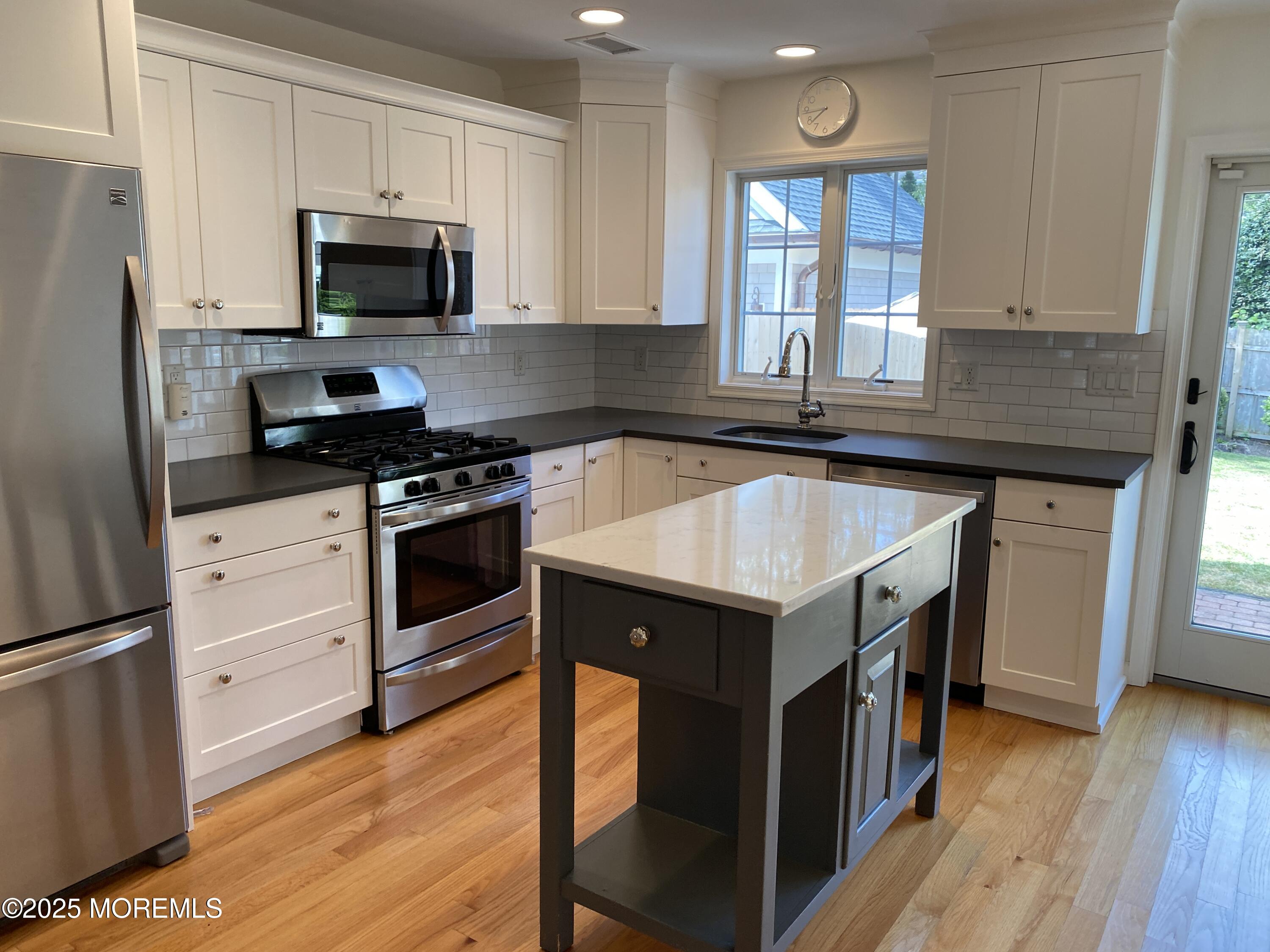 32 1st Street Rumson, NJ 07760 - Photo 9 of 25 a kitchen with a stove a sink and a refrigerator