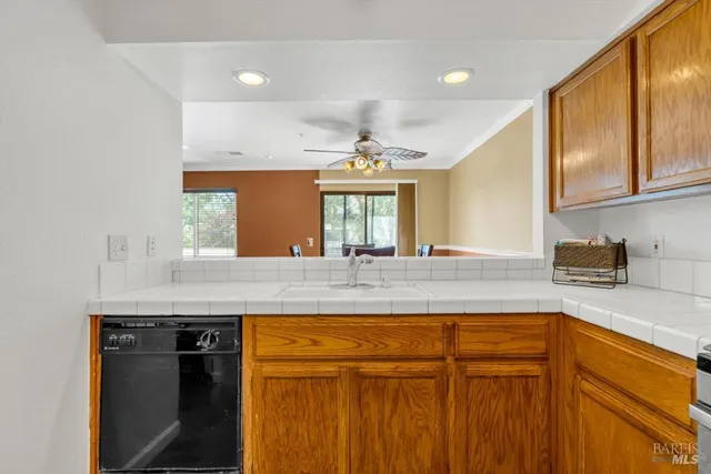 a kitchen with kitchen island granite countertop a sink window and cabinets
