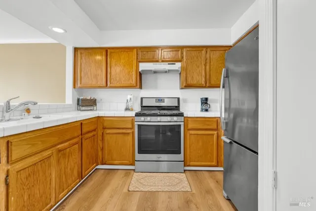 a kitchen with a refrigerator sink and cabinets
