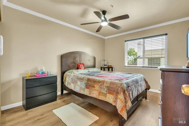a bedroom with a bed chandelier and a window